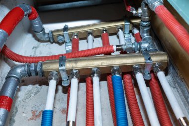 Boruları ve su dağıtıcısı olan teknik bir bacanın içi. Banyo odasında su dağıtım ve dallanma merkezi..