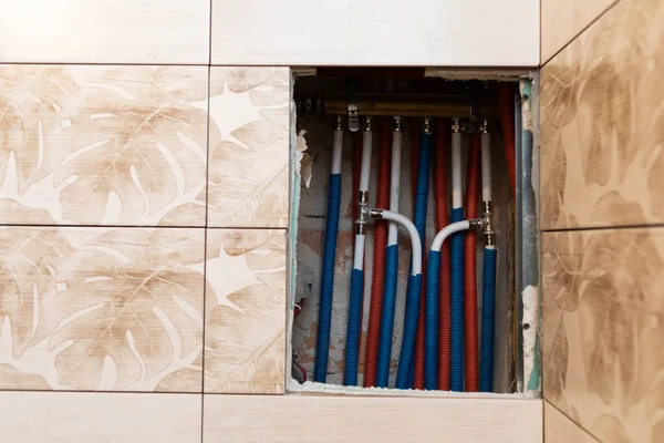 Het interieur van een technische schacht met leidingen en een waterverdeler. Centrum voor vertakking en distributie van water in de badkamer. — Stockfoto