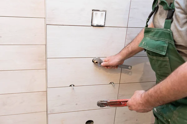 The plumber began regulating the water approaches for the installation of the urinal. An employee from the hydraulic industry. — kuvapankkivalokuva