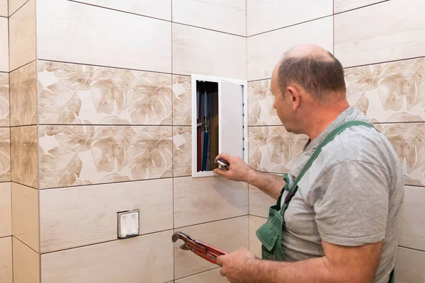 Un empleado se prepara para renovar y regular el suministro de agua en el baño. Plomero está planeando una renovación . —  Fotos de Stock