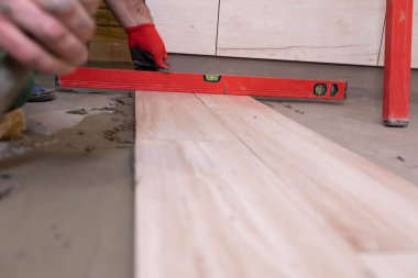 Ruh seviyesi - çalışmaların seviyesine göre doğruluğunu kontrol eden bir aygıt. Profesyonel bir inşaat işçisi. Diz çök.