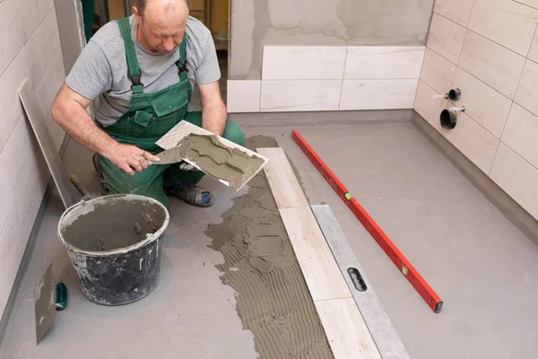 Operaio Edile Lubrifica Fondo Della Piastrella Ceramica Con Una Spatola — Foto Stock