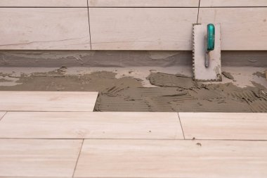 El aleti. Kare dişli metal mala. Çimento ve terakottayı yapıştırıcı ile döşemek için kullanılan bir araç.