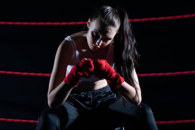 Güçlü bir MMA oyuncusunun kayıp dövüşü. O bir sandalyede oturuyor. Dövüşü kaybettikten hemen sonra. Ringdeki kavgadan sonra üzgün bir kadın..