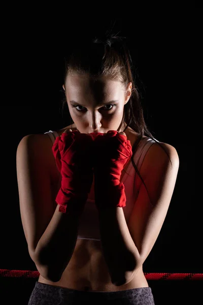 The head is hidden behind the strong guard of a professional sportswoman. A strong and athletic woman in the ring of sports which is MMA.