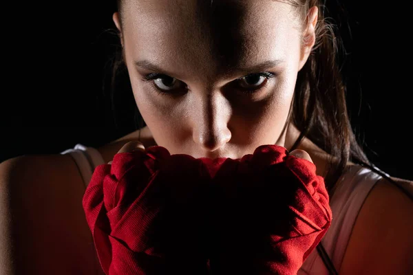 The head is hidden behind the strong guard of a professional sportswoman. A strong and athletic woman in the ring of sports which is MMA.