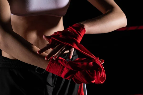 A woman prepares for an MMA fight, wrapping her hands in a special boxing bandage. Strong woman. The inevitable fight in the ring.