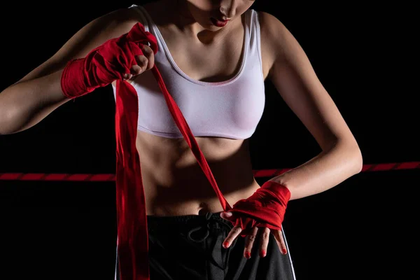 A woman prepares for an MMA fight, wrapping her hands in a special boxing bandage. Strong woman. The inevitable fight in the ring.