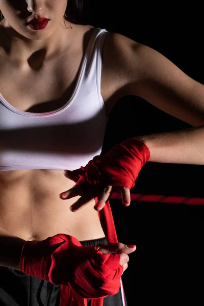 A woman prepares for an MMA fight, wrapping her hands in a special boxing bandage. Strong woman. The inevitable fight in the ring.