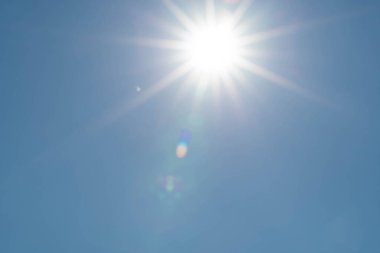 Yaz ve tatil zamanlarında bulutsuz bir günde keskin güneş ışınları. Açık mavi gökyüzü arkaplanı.