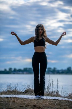 Sakin sularda yoga yapan bir kadının sakin ve huzurlu bir atmosfer yarattığı sakin bir siluet.