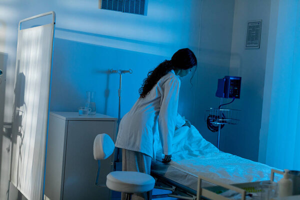 Специалист по кардиологии заботливо ухаживает за пациентом в промозглой атмосфере больничной палаты