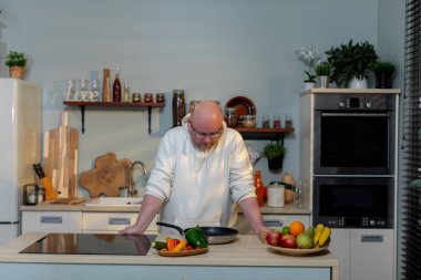 Yetenekli ve yetenekli bir şef modern bir mutfakta taze ve canlı sebzeler kullanmaya odaklanır.