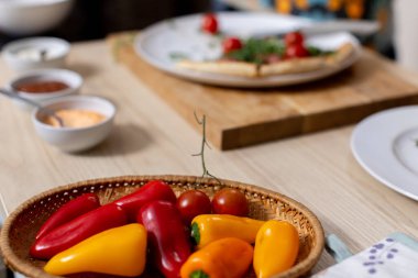 Kırsal bir masada taze biber ve domates rengarenk bir düzen. Mutfak ilhamı için mükemmel..
