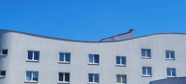 Çarpıcı derecede parlak mavi gökyüzünün altındaki dalgalı modern bir binanın büyüleyici ve büyüleyici görüntüsü.