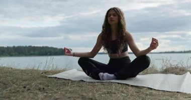 Huzurlu göl kenarında huzurlu ve sakin bir yoga pratiği yapmak rahatlama ve farkındalık için harikadır.