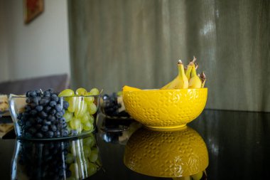 Zarif bir şekilde düzenlenmiş taze muz ve üzümlerin hoş, canlı ve renkli bir gösterisi.