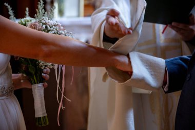 Bu güzel düğün töreninde çiftlerin ellerinin yürekten yeminlerini ettikleri gerçekten dokunaklı bir an.