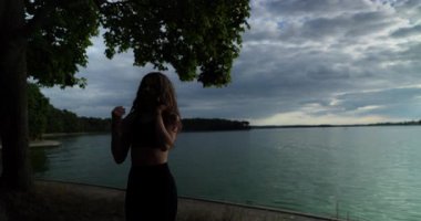 Huzurlu göl kıyısında bir siluet çarpıcı güzellikteki güzel bir yansımayı yakalar.