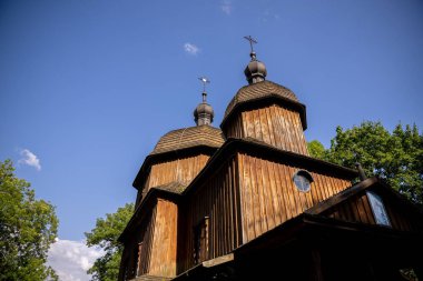 Eşsiz kubbeleriyle nefes kesici ahşap bir kilise tepemizde canlı, mavi, güneşli bir gökyüzüne gururla duruyor.