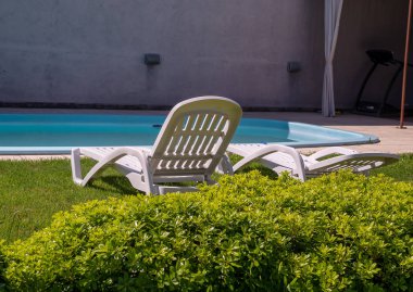 Şezlong ve tropikal bahçe mavi Yüzme Havuzu. Dinlenme ve boş zaman faaliyetleri için kullanılır.