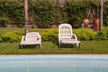 Şezlong ve tropikal bahçe mavi Yüzme Havuzu. Dinlenme ve boş zaman faaliyetleri için kullanılır.