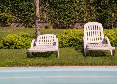 Şezlong ve tropikal bahçe mavi Yüzme Havuzu. Dinlenme ve boş zaman faaliyetleri için kullanılır.