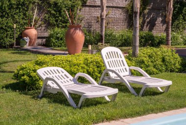 Şezlong ve tropikal bahçe mavi Yüzme Havuzu. Dinlenme ve boş zaman faaliyetleri için kullanılır.