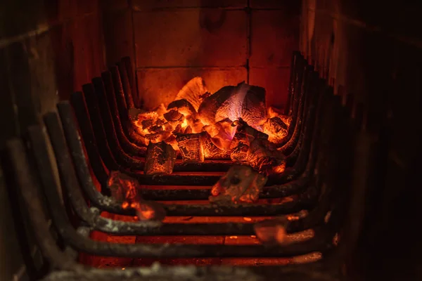 Bright hot coals and burning woods in bbq grill pit. Glowing and flaming charcoal, barbecue, red fire and ash. Weekend recreation background. Close-up.