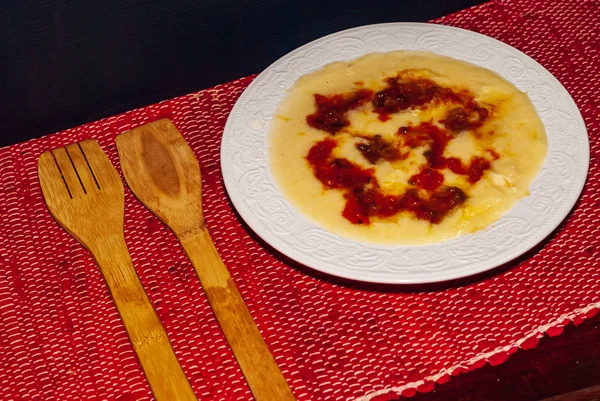 Piatto di polenta, cibo biologico italiano con latte, zucca e formaggio, e salsa rossa con pomodoro e basilico fresco. Studio orizzontale girato . — Foto Stock