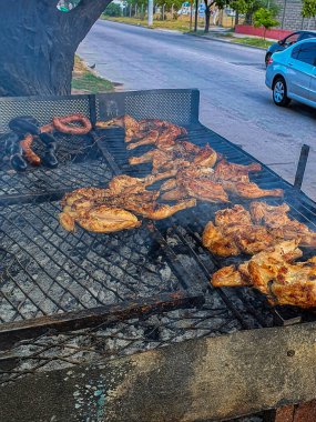 Çeşitli boyutlarda ızgara tavuk. Düşük ısıda kömür ocağı, sokak pazarı, Arjantin 'de sokak yemekleri restoranları var..