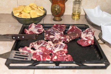 Masalarda farklı türde çiğ et var. Kırsal arka planda.