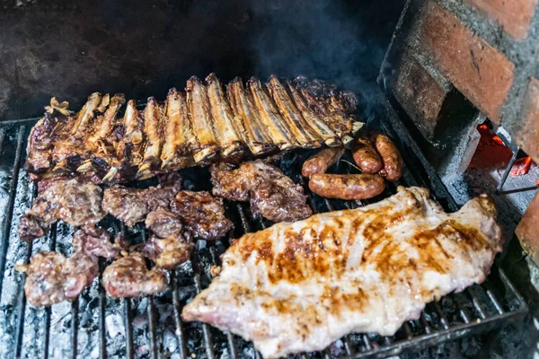 Parrillada 阿根廷烤肉用生煤 无火焰 Asado Chorizo 和烤牛肉排骨与热架上 近距离 集中选择 — 图库照片