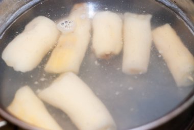 Kaynar suyla birlikte tencerede manyok pişirmek. Mandioca, yuca, balinghoy, mogo, mandioca, kamoteng kahoy, tapyoka ve tapyoka kökü olarak da bilinir. Seçici odaklan.