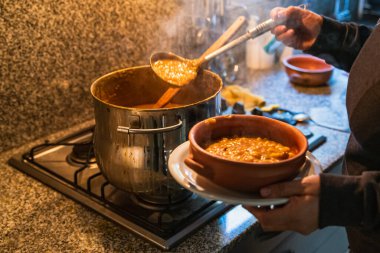 Locro servis eden kadın, tipik Arjantin yemekleri, el yapımı seramik tabaklarda..