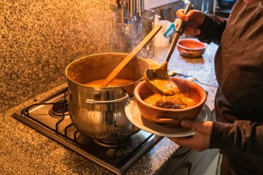 Locro servis eden kadın, tipik Arjantin yemekleri, el yapımı seramik tabaklarda..