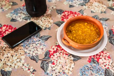 Locro, tipik ve geleneksel Arjantin yemekleri, el yapımı kil tabaklar, yanında ekmek ve bir bardak şarap, kaşıklarla..