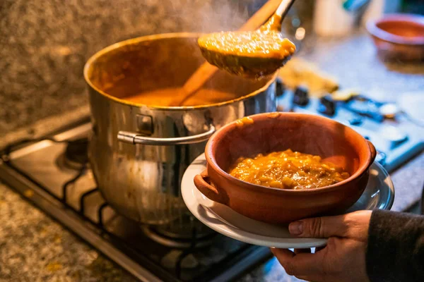 Locro servis eden kadın, tipik Arjantin yemekleri, el yapımı seramik tabaklarda..