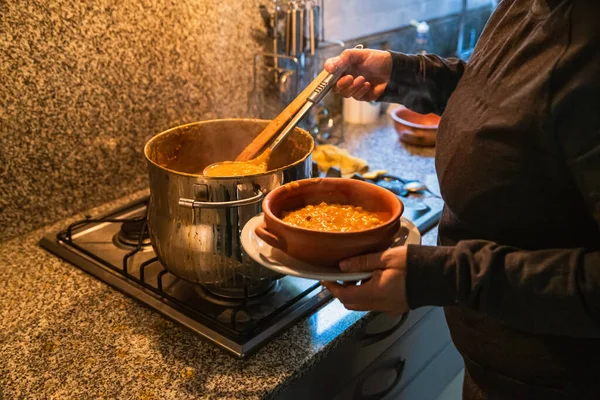 Locro servis eden kadın, tipik Arjantin yemekleri, el yapımı seramik tabaklarda..