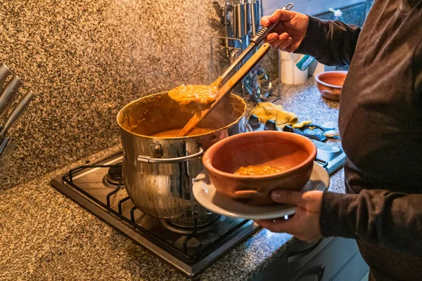 Locro servis eden kadın, tipik Arjantin yemekleri, el yapımı seramik tabaklarda..