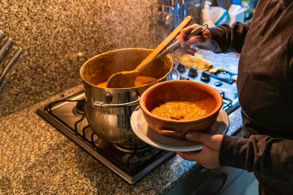 Locro servis eden kadın, tipik Arjantin yemekleri, el yapımı seramik tabaklarda..