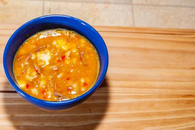 Locro, tipik ve geleneksel Arjantin yemekleri ahşap bir tahtanın üzerinde, yanında ekmek ve bir bardak şarapla servis edilir, kaşıklarla. Seçici odak.