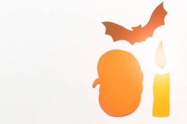 Kağıt kabaklar, yarasalar, beyaz arka plan üzerinde mumlar ile Halloween süslemeleri. Cadılar Bayramı ve dekorasyon konsepti. Lens parlama etkisi. Düz döşeme, üst görünüm, kopyalama alanı