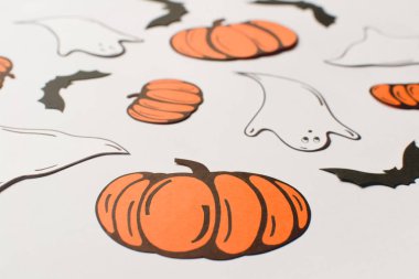 Kağıt kabaklar, yarasalar, mumlar ve beyaz arka plan üzerinde hayaletler ile Halloween süslemeleri. Cadılar Bayramı ve dekorasyon konsepti. Düz döşeme, üst görünüm, desen