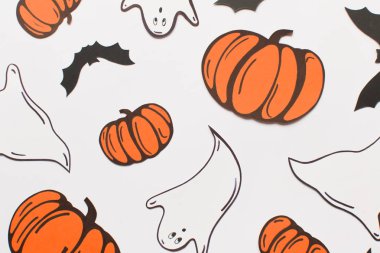 Kağıt kabaklar, yarasalar, mumlar ve beyaz arka plan üzerinde hayaletler ile Halloween süslemeleri. Cadılar Bayramı ve dekorasyon konsepti. Düz döşeme, üst görünüm, desen