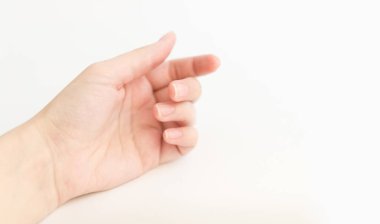 Yumuşak kare şeklinde tırnakları olan kadın eli parmaklarında bir şey tutuyor. Kadın sanal nesneyi saklar. Evde çivi bakımı. Boşluğu kopyala