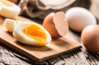 Yakın çekim haşlanmış veya çiğ tavuk yumurtası ahşap tahta üzerinde.