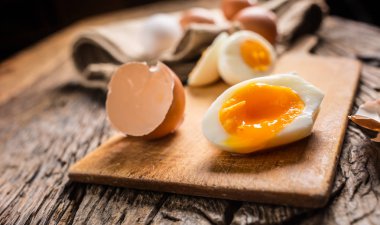 Yakın çekim haşlanmış veya çiğ tavuk yumurtası ahşap tahta üzerinde.