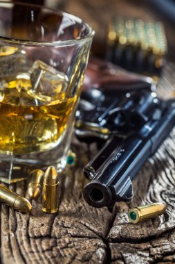 Bardak viski konyak veya bourbon tabanca ve ahşap masa mermi ile.