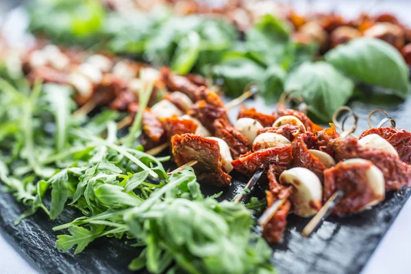 Kurutulmuş domates mozzarella fesleğen ve roka kayrak gemide Caprese salatası.